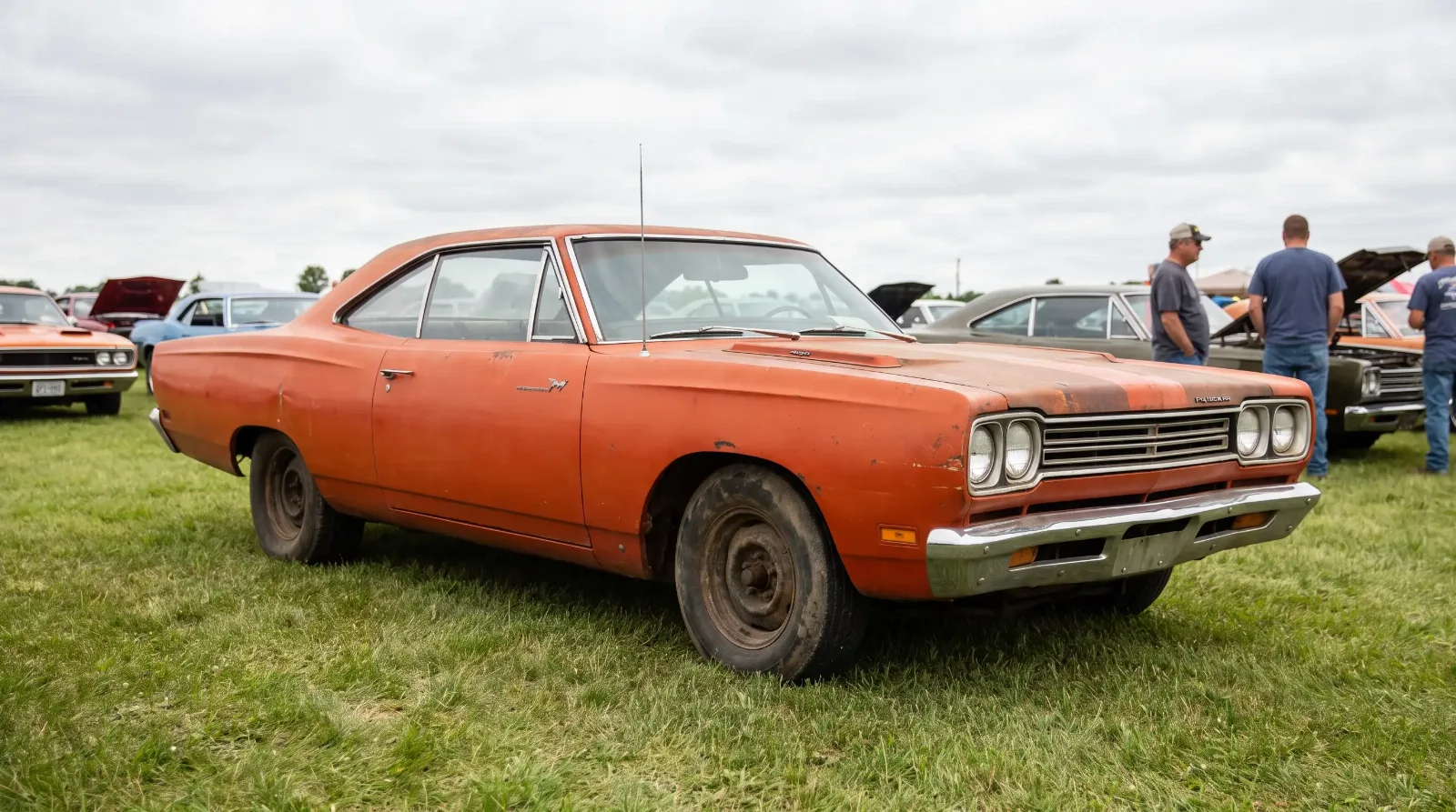 Unrestored survivor Plymouth Road Runner with faded original paint and honest patina on a show field