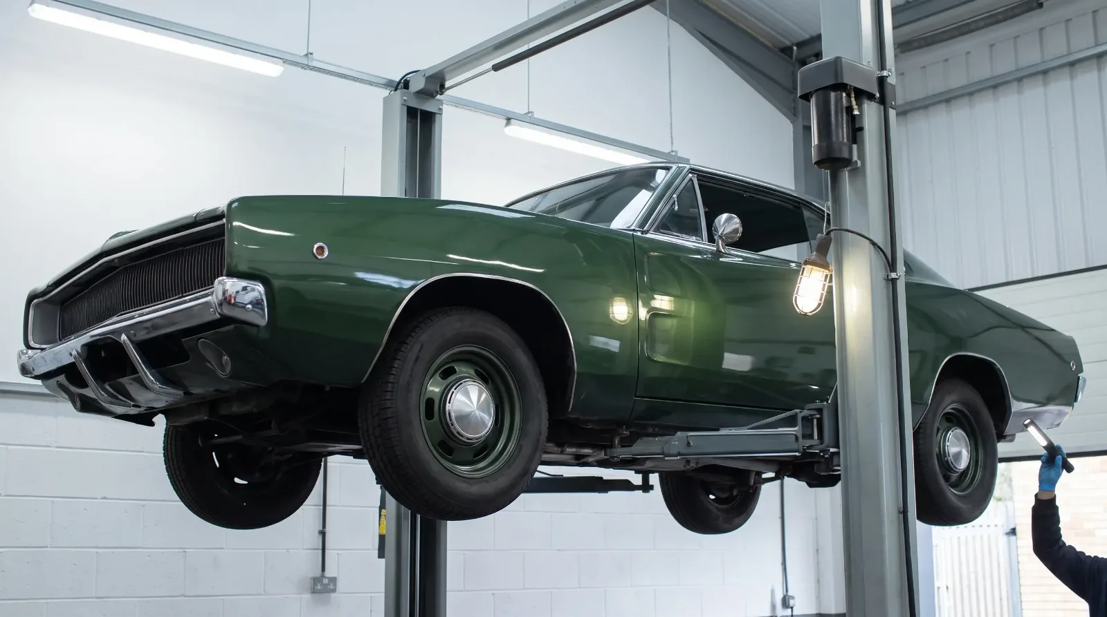 Green 1968 Dodge Charger raised on a two-post lift for an independent inspection