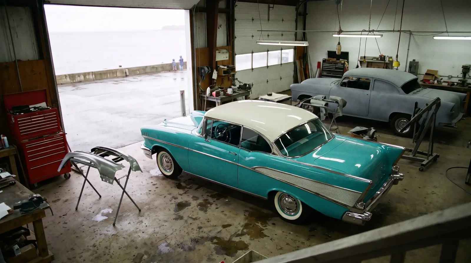 A coastal restoration shop bay with a 1957 Chevrolet Bel Air Sport Coupe