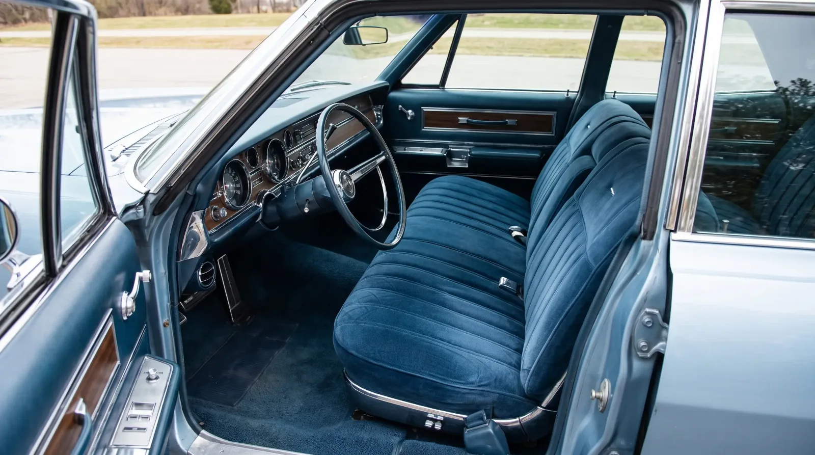 Wide bench seat interior of a 1960s American luxury car