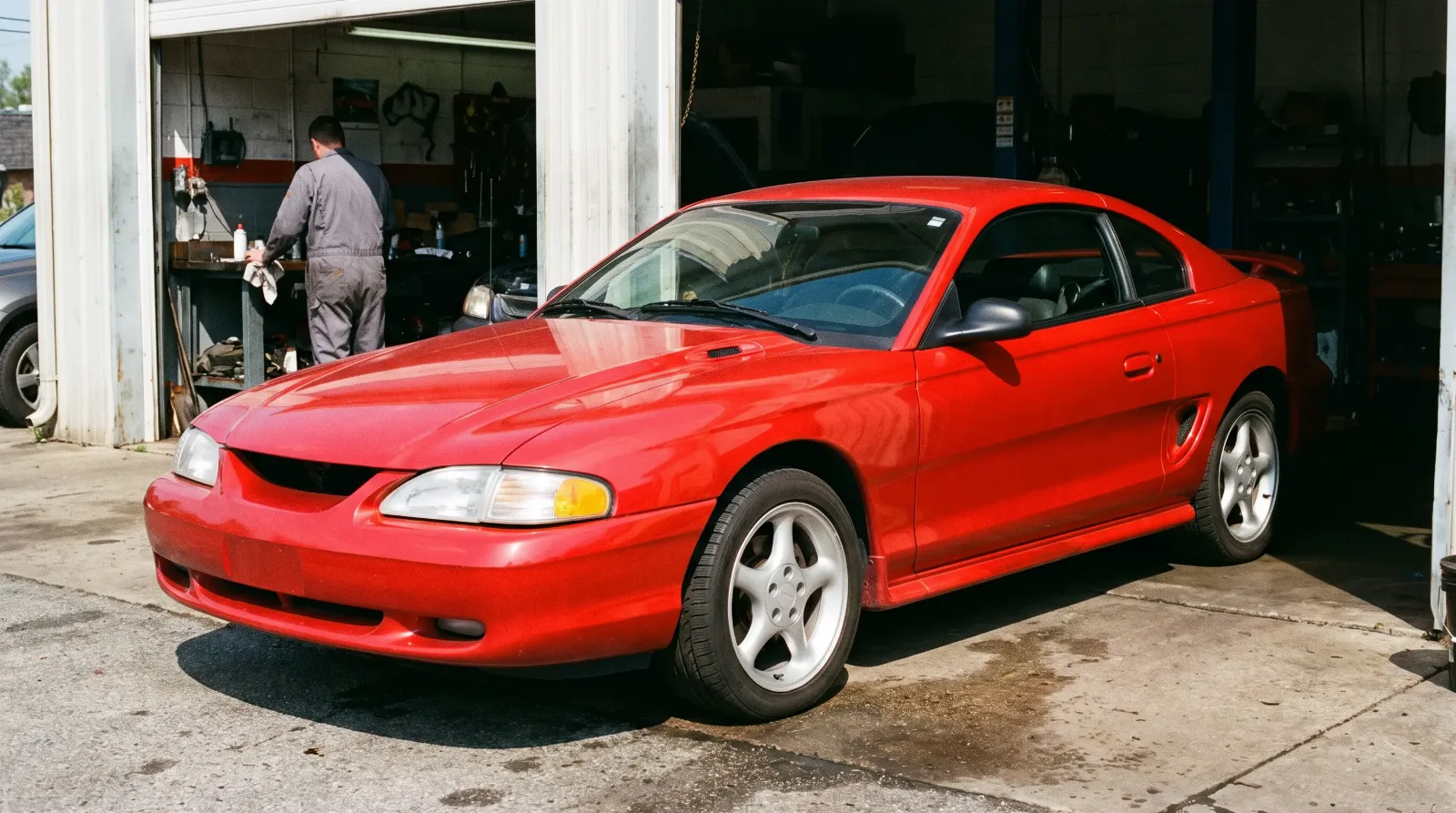 1997 Ford Mustang GT coupe, side scoop outside a garage