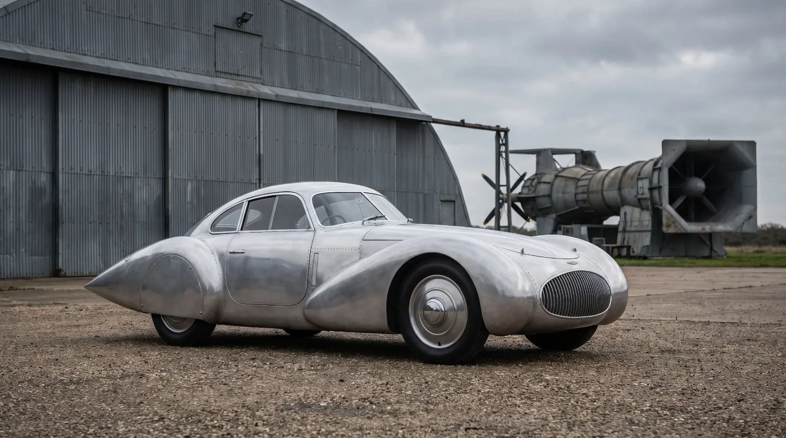 1930s teardrop concept car outside an aircraft hangar