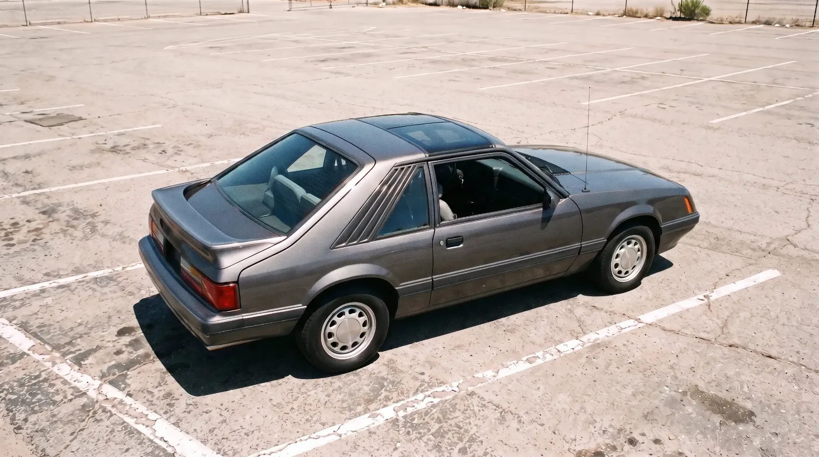 1985 Ford Mustang GT hatchback with T-tops in an empty parking lot