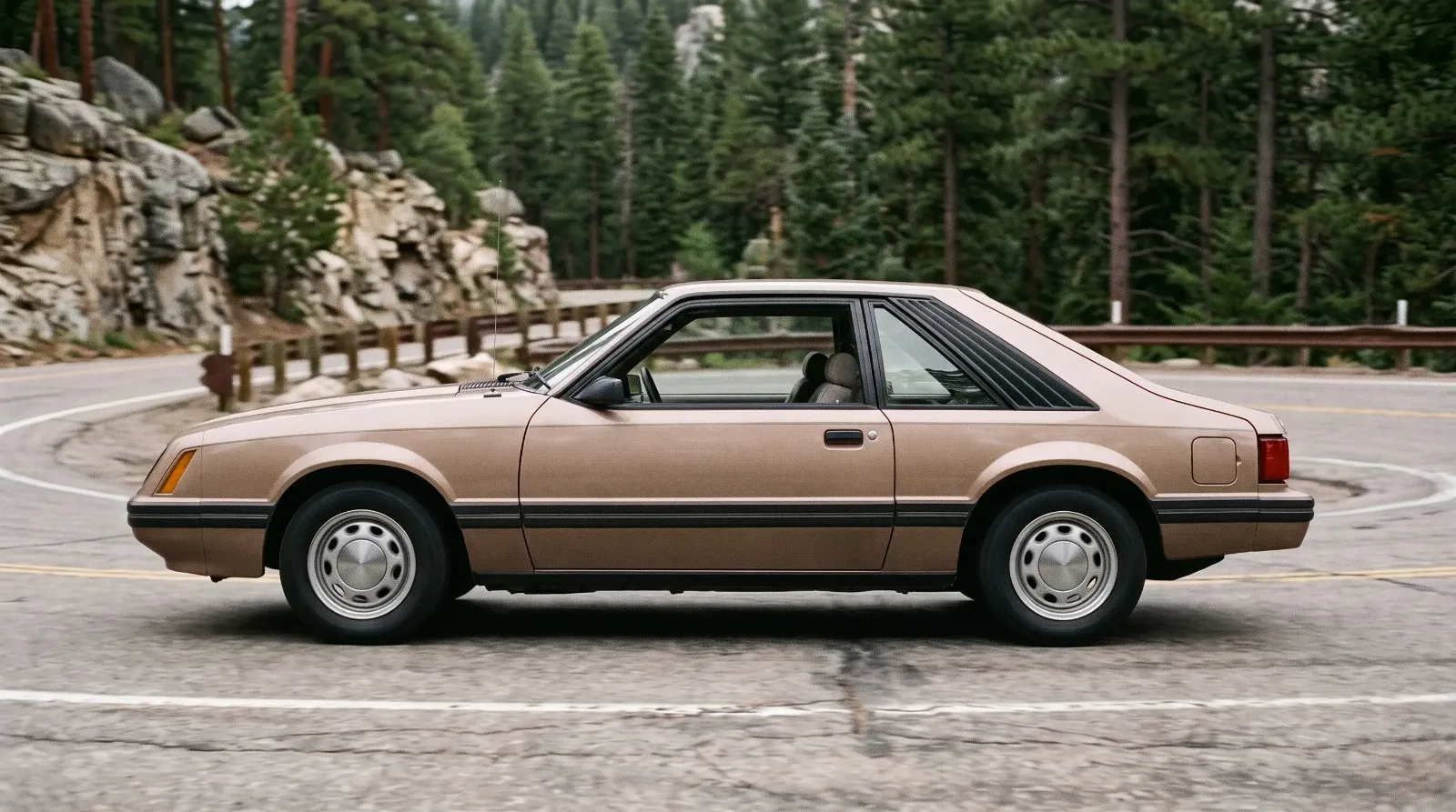 1979 Ford Mustang hatchback, rounding a mountain pass hairpin