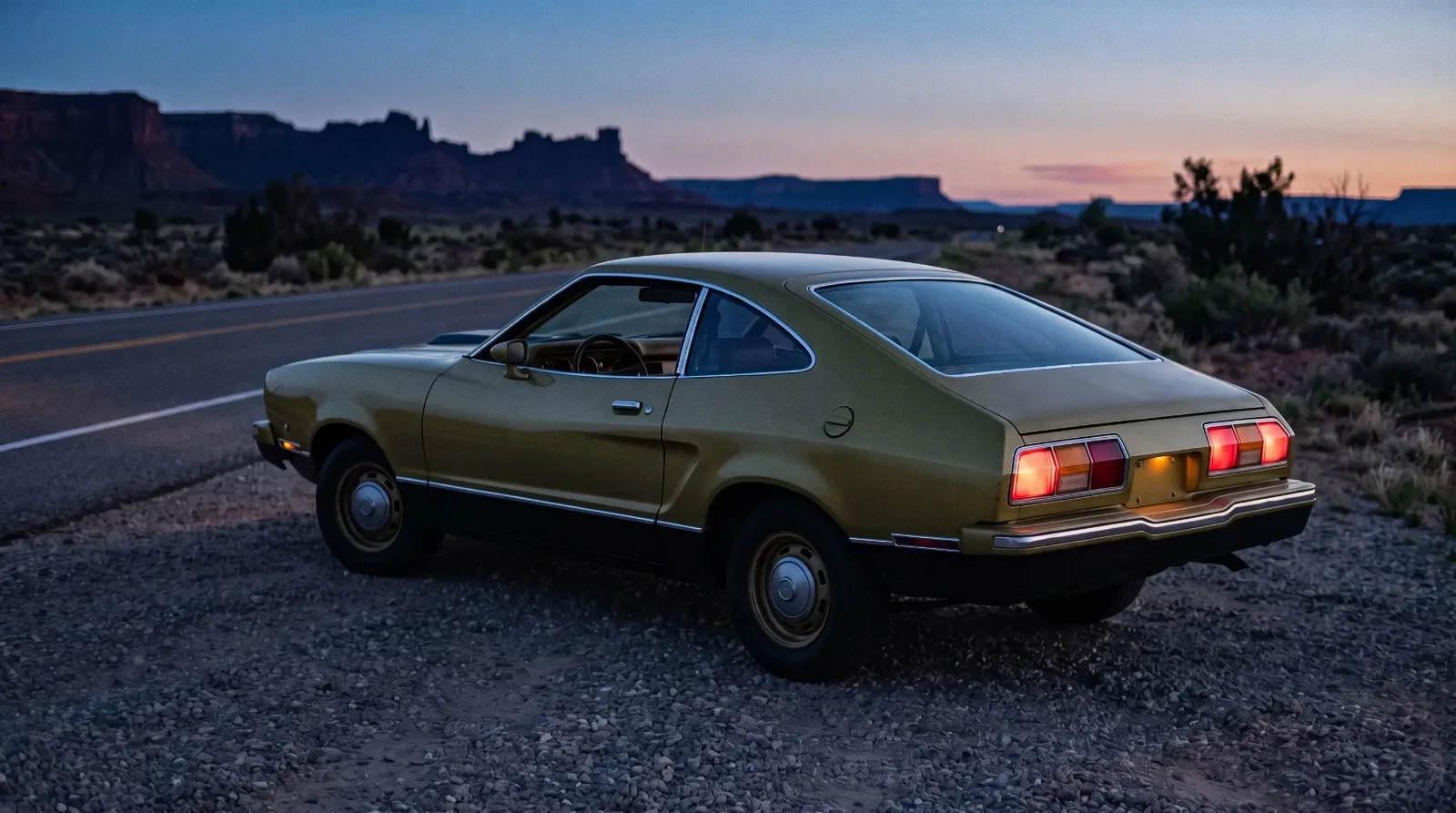 1976 Ford Mustang II Mach 1 hatchback on a desert highway at dusk