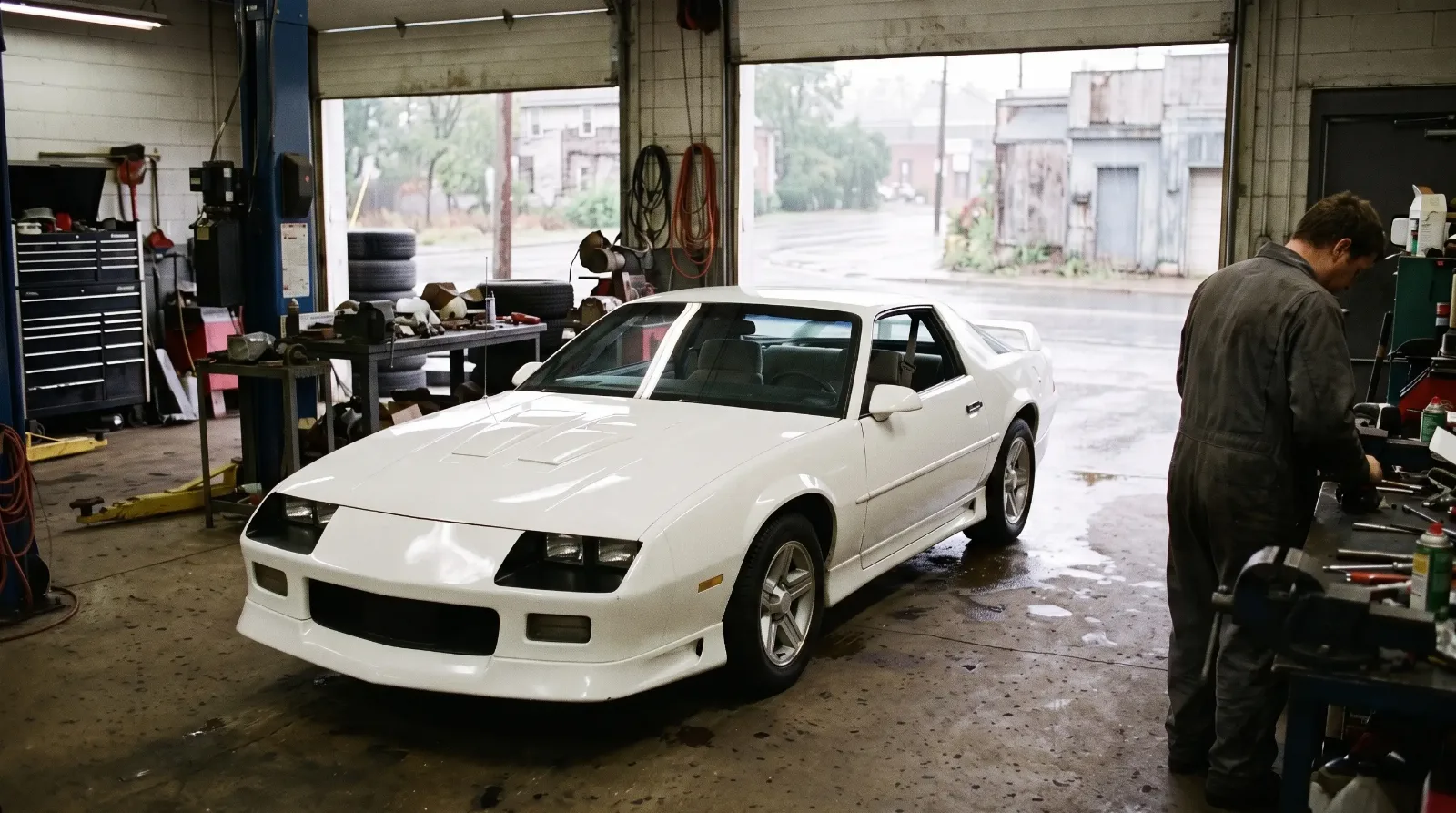 1992 Chevrolet Camaro Z28 in a repair garage on a rainy day