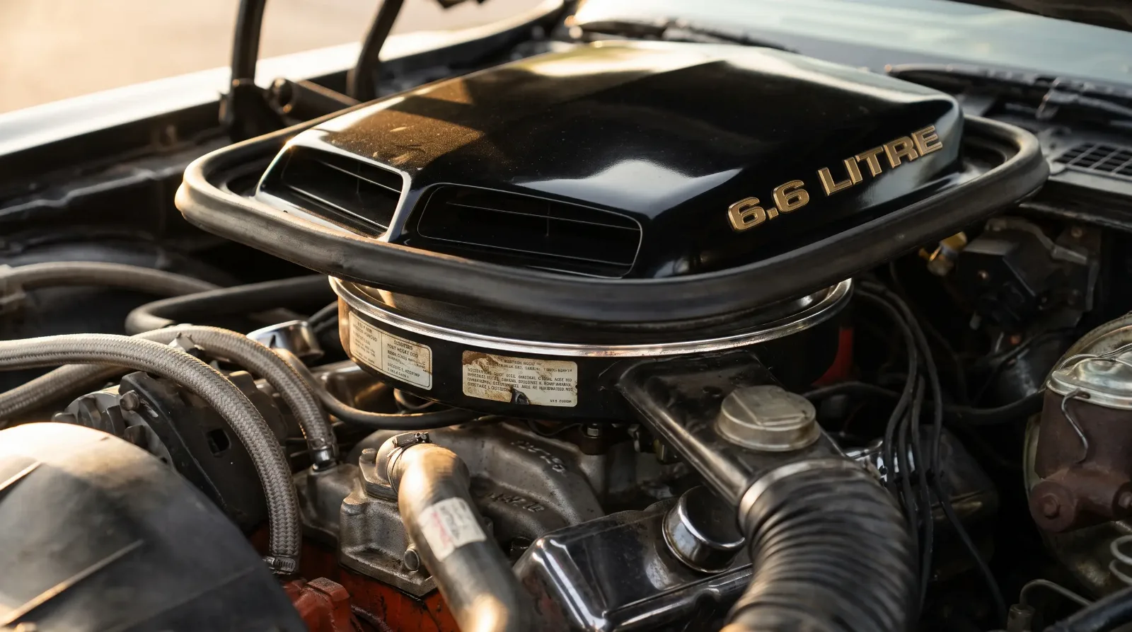 Close-up of a late 1970s Pontiac Trans Am shaker hood scoop with gold 6.6 Litre badge over the W72 400 V8