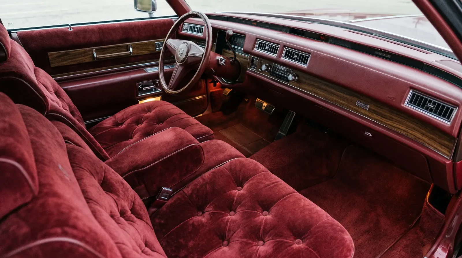 Button-tufted crushed velour seats and woodgrain dashboard
