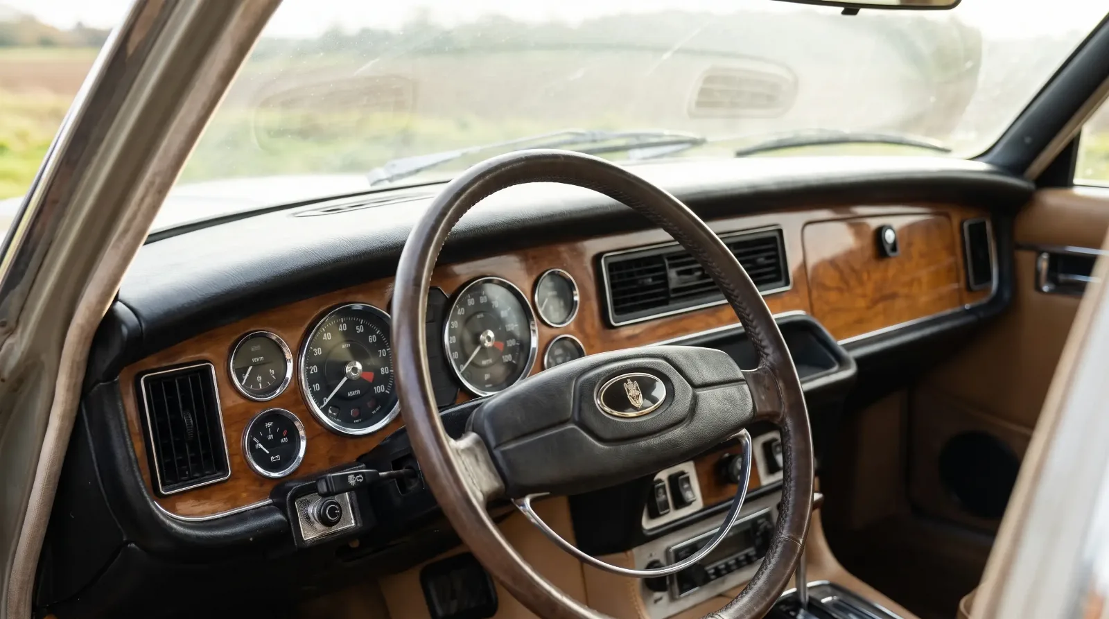 Walnut dashboard and leather steering wheel of a 1972 Jaguar XJ6 from the driver's seat