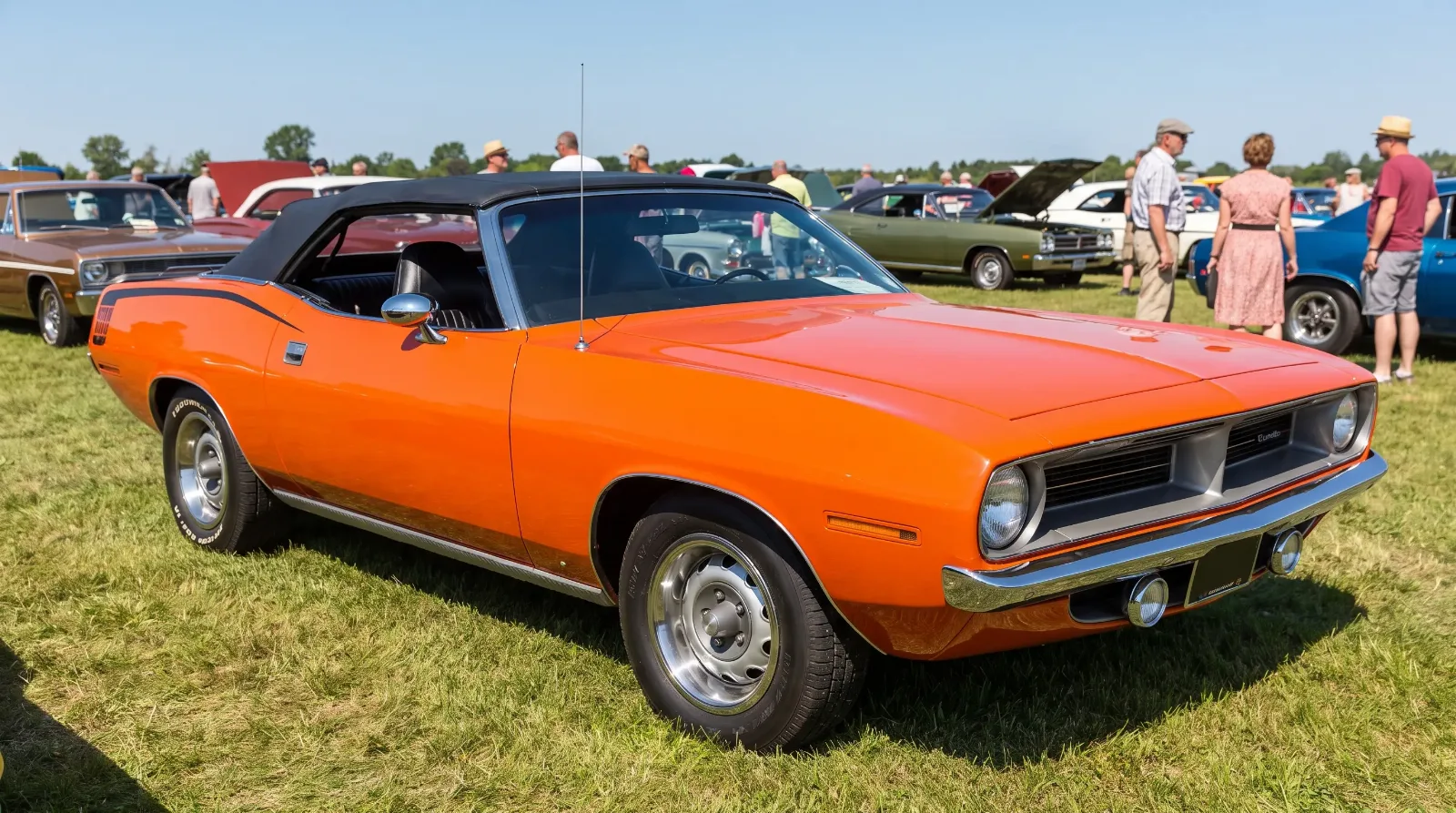 1970 Plymouth Cuda convertible in orange with the top down on a show field